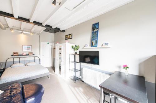a bedroom with a bed and a desk in a room at "Arends nest" in Heers