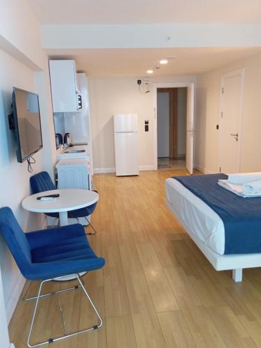 a bedroom with a bed and a table and chairs at Orbi sea view aparthotel in Angisa