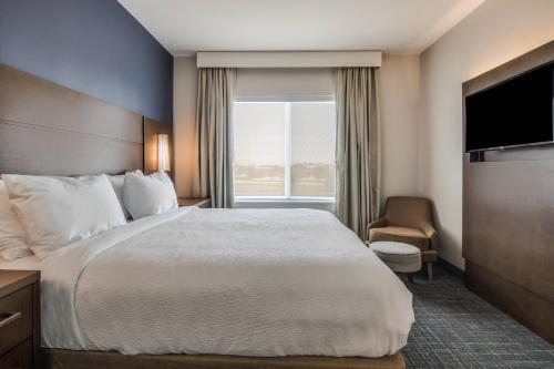a hotel room with a large bed and a window at Residence Inn by Marriott Dallas DFW Airport West/Bedford in Bedford