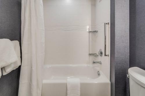 a white bathroom with a tub and a toilet at Residence Inn by Marriott Dallas DFW Airport West/Bedford in Bedford