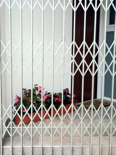 a white gate with flowers in pots behind it at Casa delle begonie in Rome