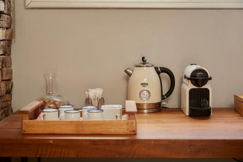 a tray of coffee cups and a tea kettle on a table at La Quebrada Potrerillos - Lodges de Montaña in Potrerillos