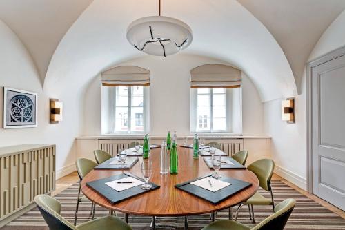 a large dining room with a wooden table and chairs at Augustine, a Luxury Collection Hotel, Prague in Prague