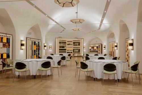 a dining room with white tables and chairs at Augustine, a Luxury Collection Hotel, Prague in Prague
