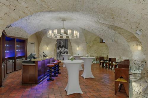 a kitchen with a stone wall and a dining room at Augustine, a Luxury Collection Hotel, Prague in Prague