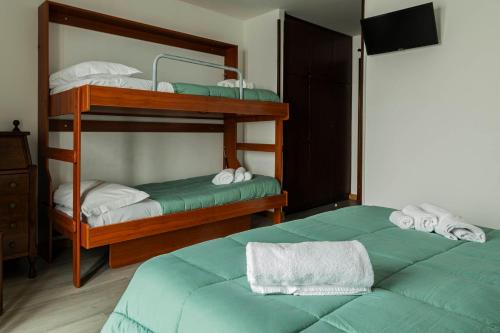 two bunk beds in a room with two green beds at Hotel Galassia in Prato Nevoso