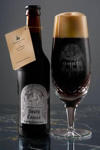 a bottle of beer sitting next to a glass at Augustine, a Luxury Collection Hotel, Prague in Prague