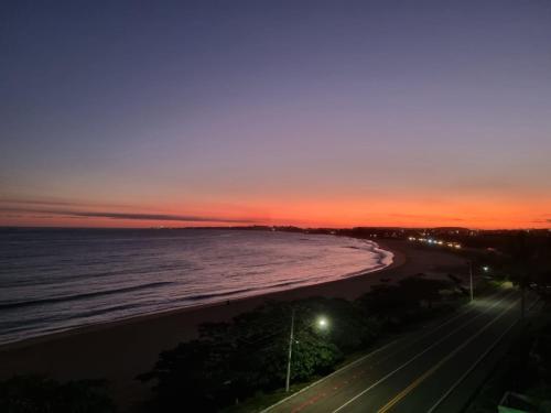 a view of a beach at night with the ocean at Jabuticaba Sabará - Frente ao Mar na Praia de Meaípe, Guarapari in Guarapari