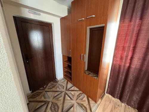 a hallway with two wooden cabinets and a floor at Casa Leone Hotel&Restaurant in Popova Shapka