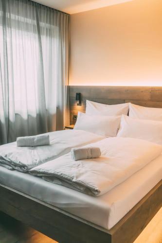 a large white bed in a room with a window at LIVALPIN 2Enjoy in Garmisch-Partenkirchen