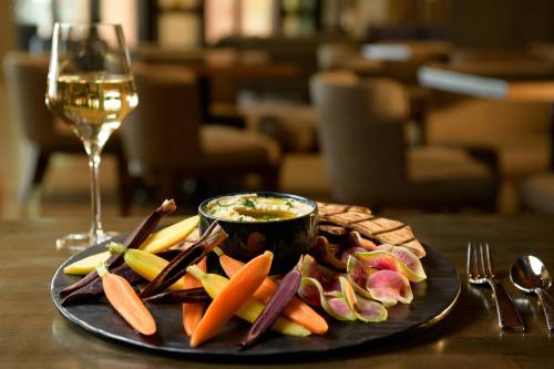 a plate of vegetables and a glass of wine on a table at Marriott Tacoma Downtown in Tacoma