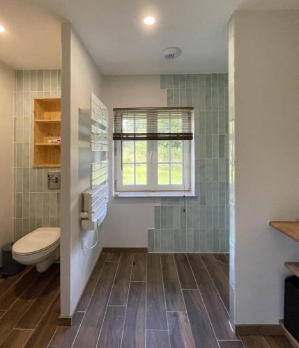 une salle de bain avec toilettes et fenêtre dans l'établissement Les gîtes de la Courtille, à Équihen-Plage