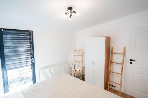 a bedroom with a white bed and a window at TheNest in Mărişel