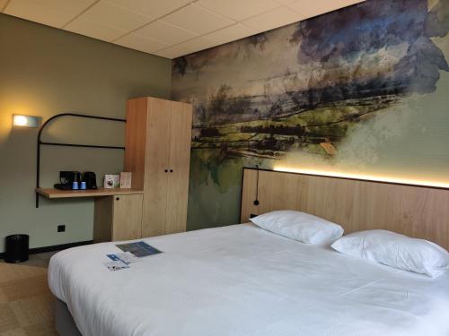 a bedroom with a bed and a painting on the wall at Fletcher Hotel-Restaurant Marknesse in Marknesse