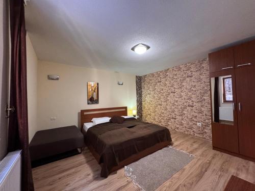 a bedroom with a bed and a brick wall at Casa Leone Hotel&Restaurant in Popova Shapka
