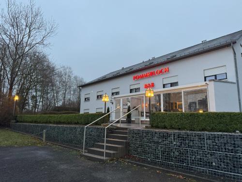a white building with a red sign on it at B&B Pommerloch in Pommerloch