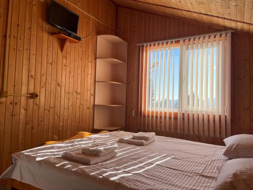 Un dormitorio con una cama con dos toallas encima. en Котедж Краєвид, en Yablunytsya