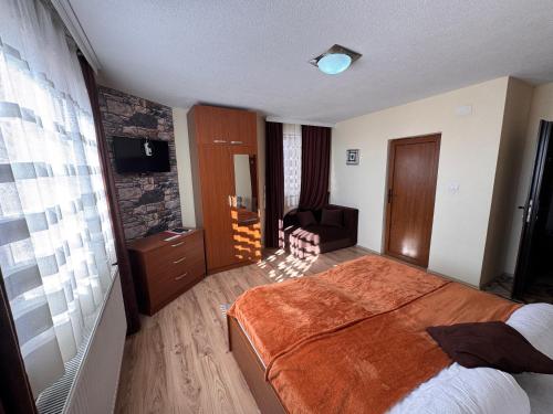a hotel room with a bed and a chair in it at Casa Leone Hotel&Restaurant in Popova Shapka