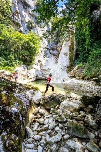 two people walking across rocks in a river at Apartmani Xenia & Desiderio in Buzet