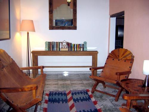 a living room with two chairs and a piano at El Zopilote Mojado in Guanajuato