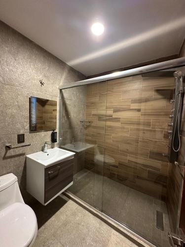 a bathroom with a shower and a toilet and a sink at Playasol Las Hadas in Manzanillo