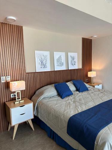 a bedroom with a bed with blue pillows on it at Playasol Las Hadas in Manzanillo
