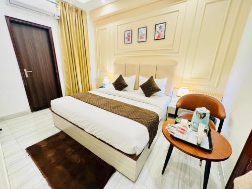 a hotel room with a bed and a table at The Classic Crowne at Delhi Airport in New Delhi