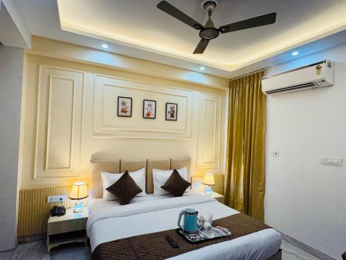 a bedroom with a large bed with a ceiling fan at The Classic Crowne at Delhi Airport in New Delhi