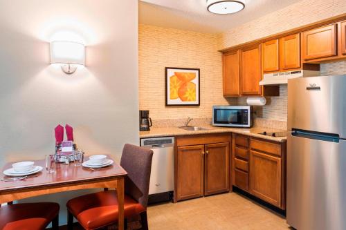 a small kitchen with a table and a refrigerator at Residence Inn Huntsville in Huntsville