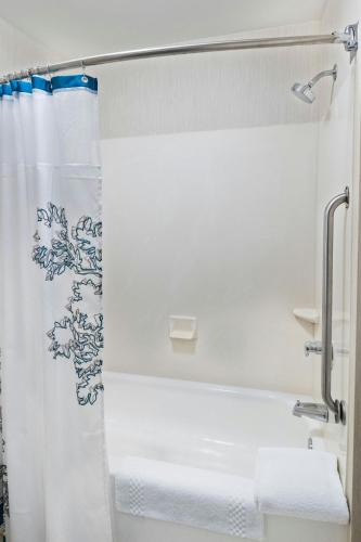 a bathroom with a shower curtain and a tub at Residence Inn Huntsville in Huntsville