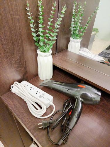 a hair dryer sitting on a shelf with two vases at 703-STP Homely room Free Wi-Fi and Near BTS line in Bangkok