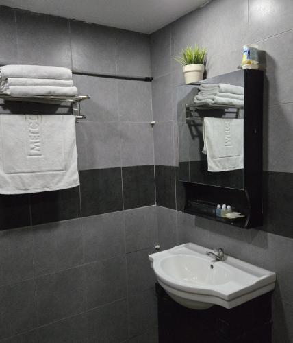 a bathroom with a sink and white towels at Residency Hotel Bangkok in Bangkok
