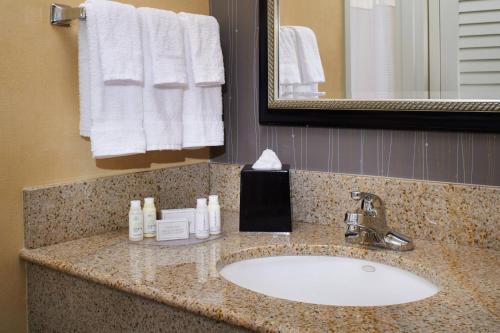 a bathroom with a sink and a mirror and towels at Courtyard Columbus Dublin in Dublin