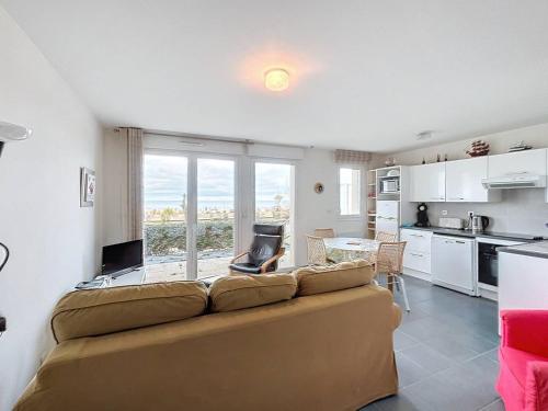 un salon avec un canapé et une cuisine dans l'établissement Appartement rez-de-jardin, front de mer, 4 pers, calme, wifi gratuit - FR-1-465-46, à Merville-Franceville-Plage