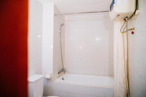 a bathroom with a tub and a toilet and a shower at Mercury Hotel & Apartment in Vung Tau
