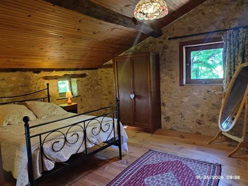 une chambre avec un lit et un plafond en bois dans l'établissement Dordogne Cottage, à Faurilles