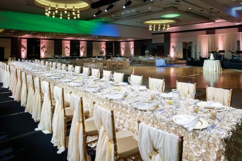 a long table with white tables and chairs in a room at Louisville Marriott Downtown in Louisville