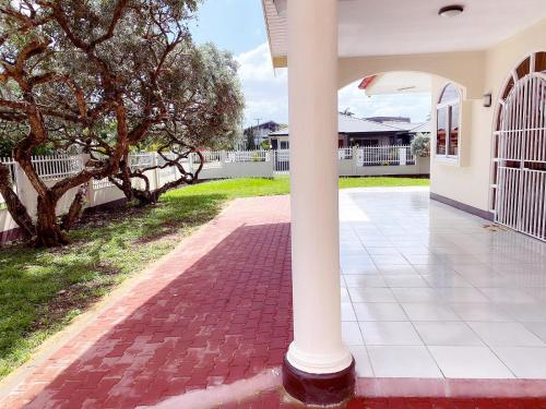 a white column in the middle of a driveway at Paramaribo Villa Near Vibrant District incl Kitchen Household Service in Paramaribo