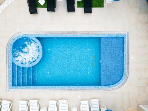 an overhead view of a swimming pool with chairs at Семеен хотел БОНЖУР in Panagyurishte