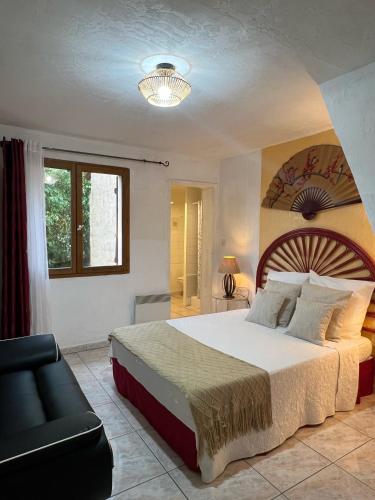 une chambre avec un grand lit et un canapé dans l'établissement Bed & Breakfast Le Beauséjour, à Carcassonne