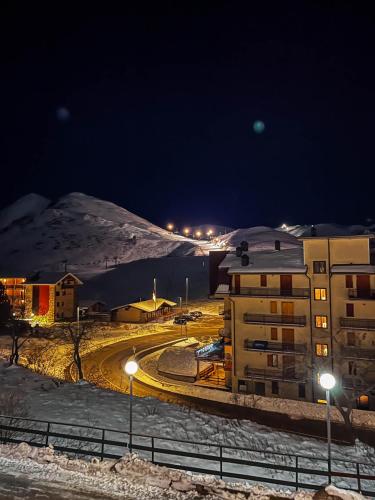 a building with street lights in the snow at night at Hotel Galassia in Prato Nevoso