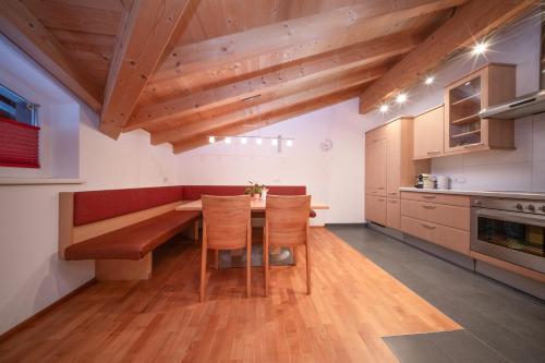 a kitchen with a wooden table and chairs at Arche Ötztal Dorfzentrum in Umhausen