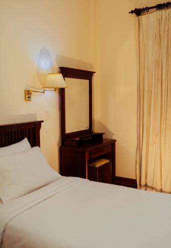 a bedroom with a bed and a dresser with a mirror at Mercury Hotel & Apartment in Vung Tau