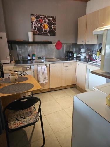 Il comprend une cuisine équipée d'une table, d'une table et d'un réfrigérateur. dans l'établissement Dans la campagne aixoise, à Meyreuil
