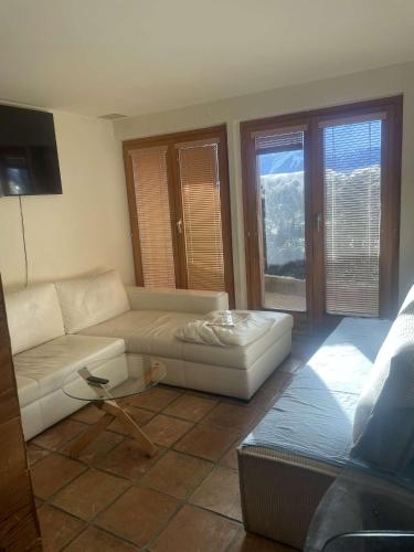 ein Wohnzimmer mit Sofa und Tisch in der Unterkunft Apparemment in Verbier