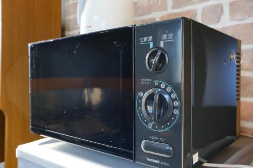 a microwave oven sitting on top of a counter at Surfing House SOMEDAY in Onjuku