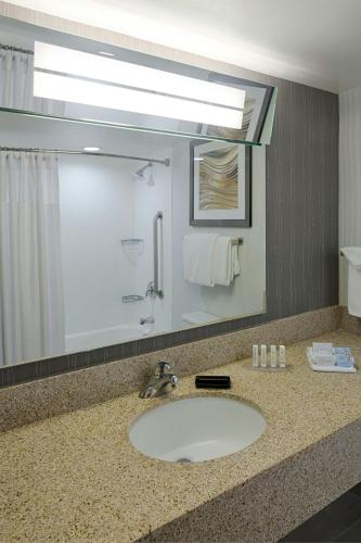 a bathroom with a sink and a large mirror at Courtyard by Marriott Columbus West/Hilliard in Columbus