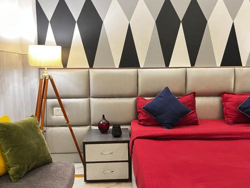 a room with a bed and a couch and a lamp at Divine Inn Hotel Near Rajouri Garden Main Market in New Delhi