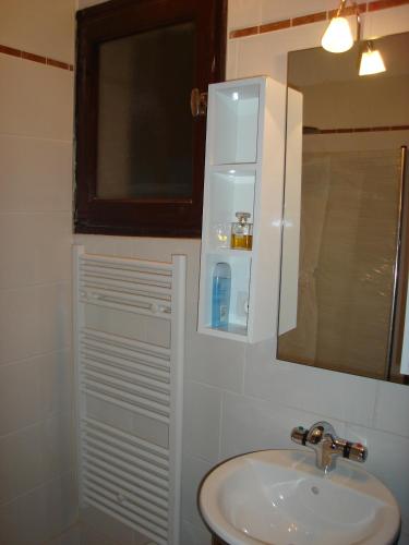 une salle de bain avec un lavabo et un miroir dans l'établissement Vue Panoramique, à Porticcio