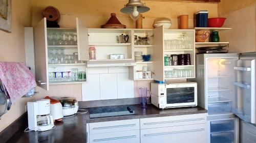  La cuisine est équipée de placards blancs et d'un réfrigérateur. dans l'établissement Vue Panoramique, à Porticcio